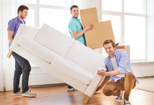 Professional movers carrying furniture through a central London street in Pimlico